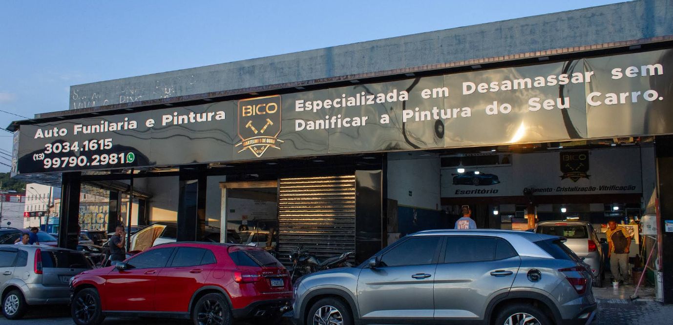 Fachada da oficina no fim da tarde, com carros de clientes na frente