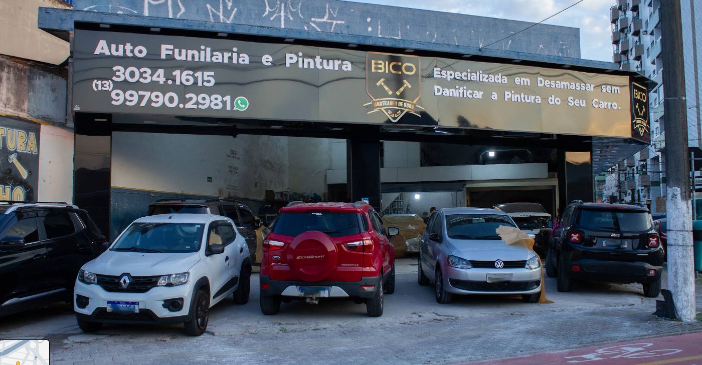 Fachada preta e dourada da oficina, com o escudo BICO e a frase: especializada em desamassar sem danificar a pintura do seu carro