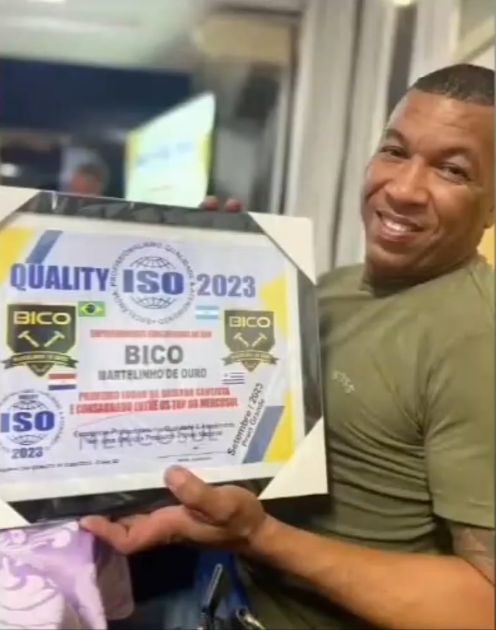O Bico sorrindo com a placa do prêmio Quality ISO 2023